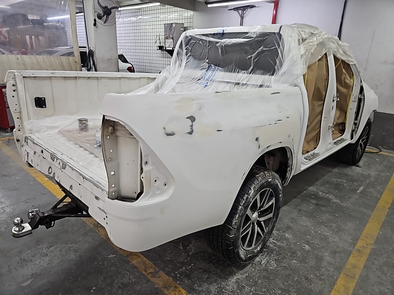 Picape mascarada com papel e plástico, com a lataria em massa, pronta para a pintura